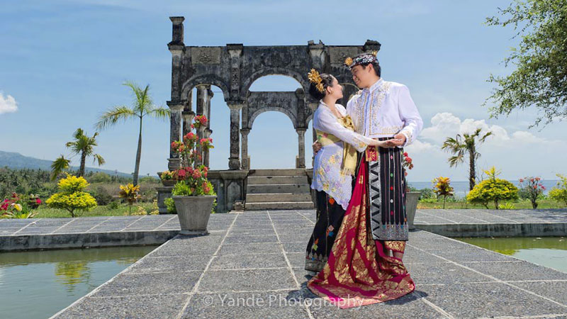 Couple in traditional Balinese attire at Taman Ujung Water Palace, one of the best pre-wedding locations in Bali