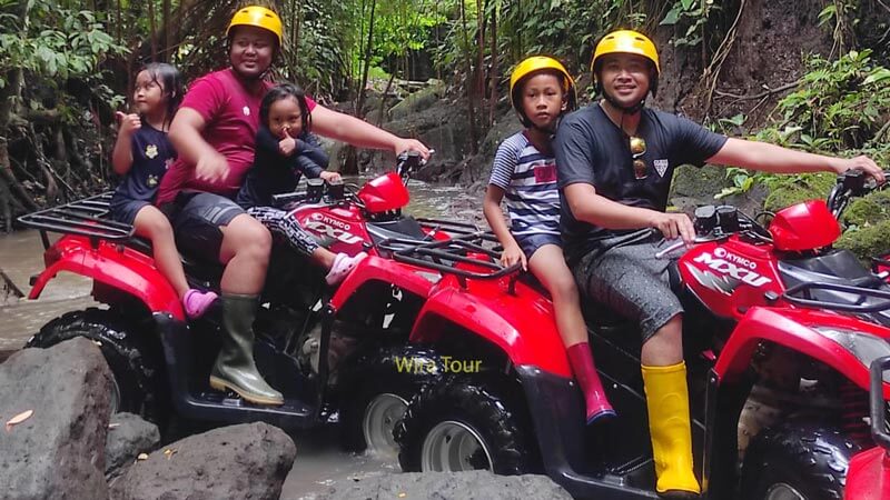 Family enjoying an ATV ride in Bali's rugged terrain after rafting