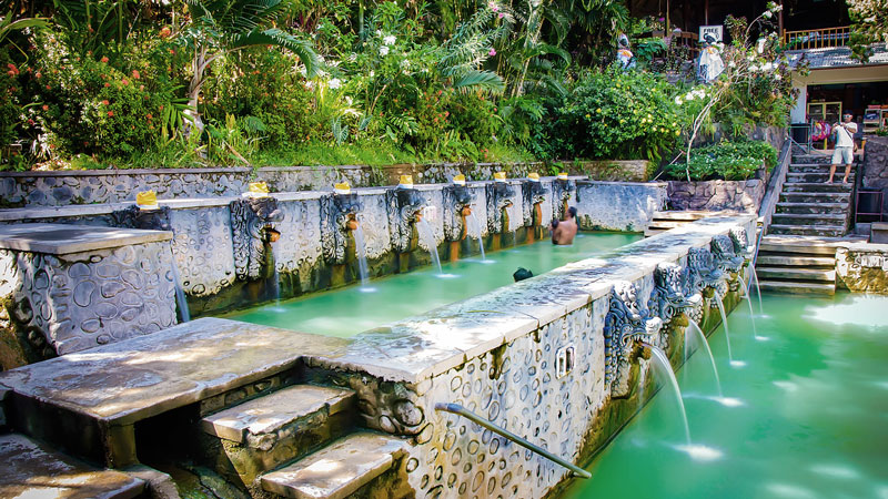 Visitors enjoying the therapeutic waters of Banjar Hot Springs surrounded by lush Balinese greenery.