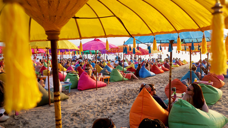 Colorful beach bean bags and umbrellas at sunset in Bali, Seminyak Travel Guide