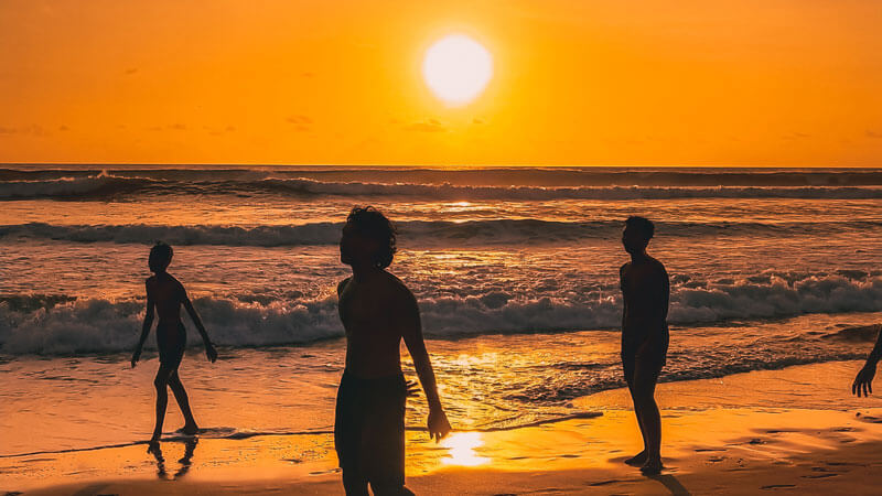 Silhouettes of people on Bali Beach at sunset. Seminyak Travel Guide