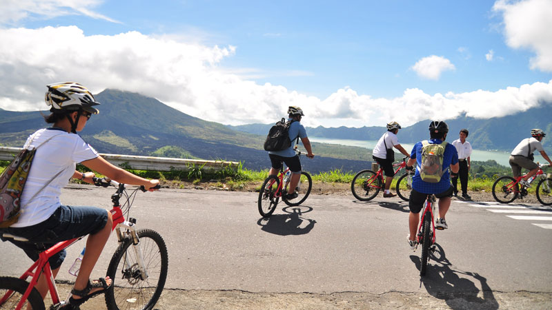 Group of cyclists enjoying the panoramic views of Kintamani's volcanic landscape on Sobek Cycling tour