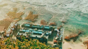 Aerial view of beach bar with blue sea background in Jimbaran