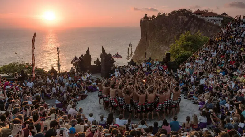 Uluwatu Temple with sunset in the background and Kecak Dance performance.