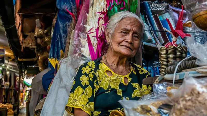 A local vendor in traditional attire selling goods at Sukawati Art Market