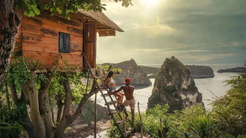 Couple at Nusa Penida Treehouse with stunning ocean and cliff views.