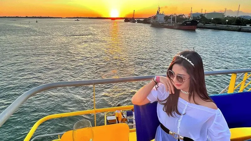 Woman enjoying sunset dinner on Bali Bounty Cruise, a budget-friendly romantic experience.