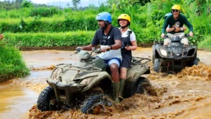 Group of ATV riders navigating muddy terrain in Bali during an adventurous off-road tour, part of Bali’s top adventure sports.