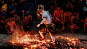 Kecak fire dance performers in traditional Balinese attire at Uluwatu Temple during an evening performance.