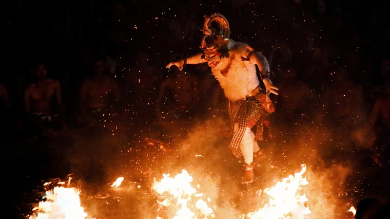 Hanoman character performing in the Kecak Dance with fire effects.