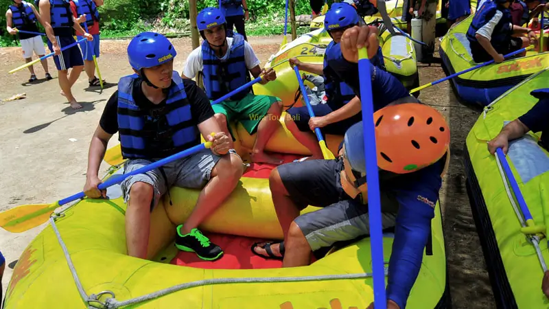 Tourists receiving a rafting safety briefing at Scenic Rafting Adventure in Karangasem, wearing helmets and life jackets before starting their adventure.