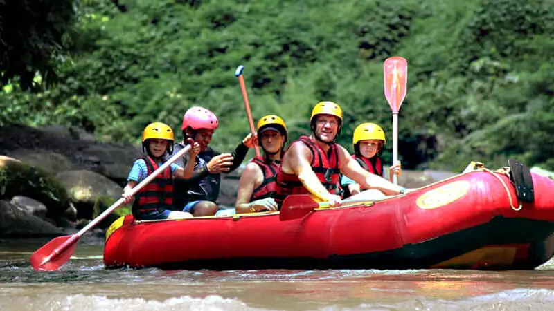 Family-friendly rafting on Ayung River in Ubud, with clear water, lush tropical scenery, and a guide leading the adventure.