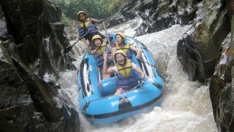 Thrilling whitewater rafting on Melangit River, featuring a group navigating fast currents and sharp turns through a narrow gorge.